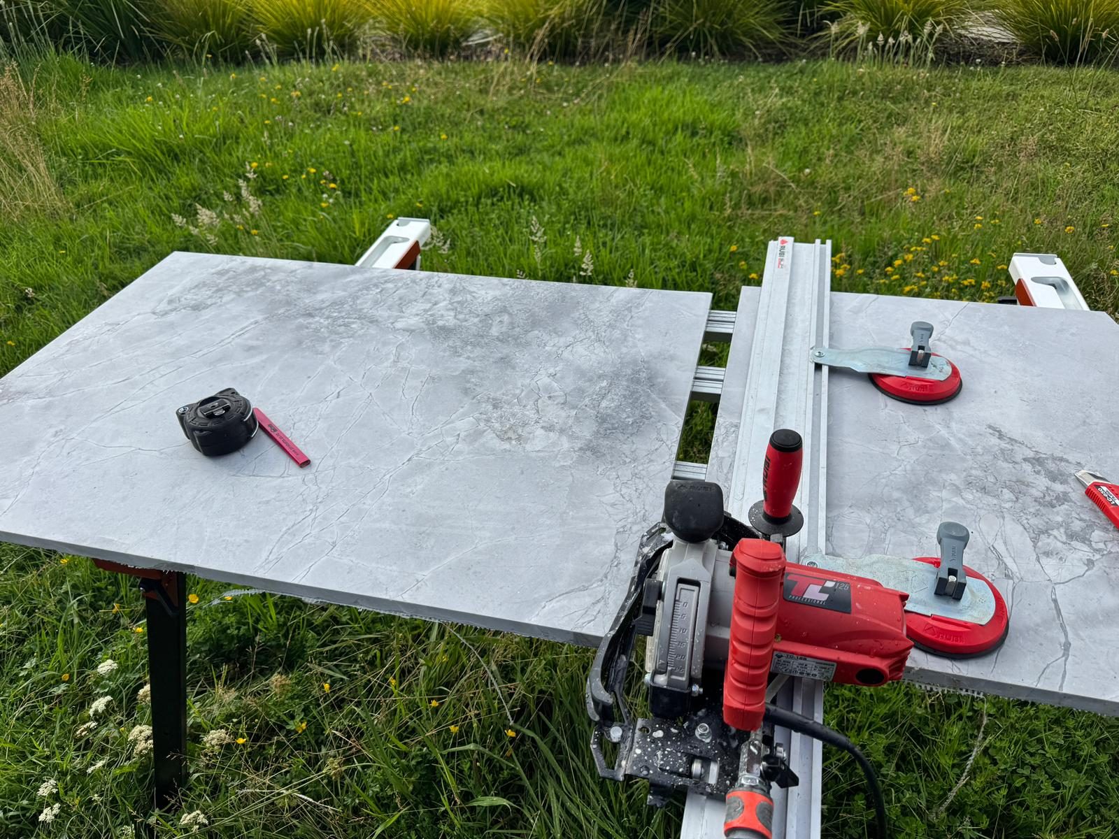 Large porcelain slab being cut on a rail cutting system with vacuum lifters