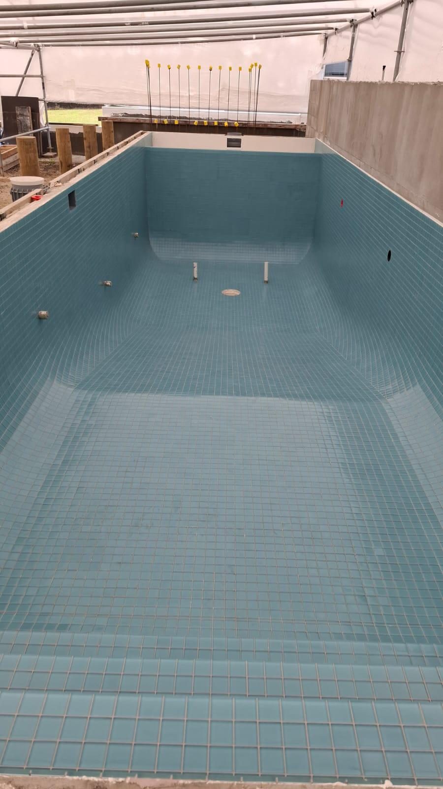 Swimming pool interior tiled in aqua glass mosaic