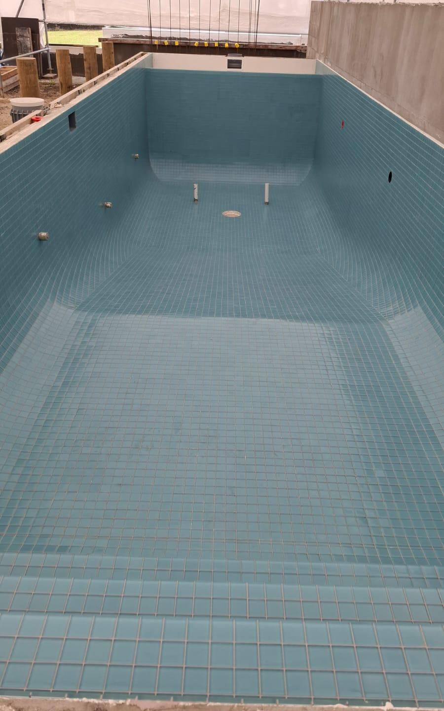 Swimming pool shell fully tiled in glass mosaic before filling