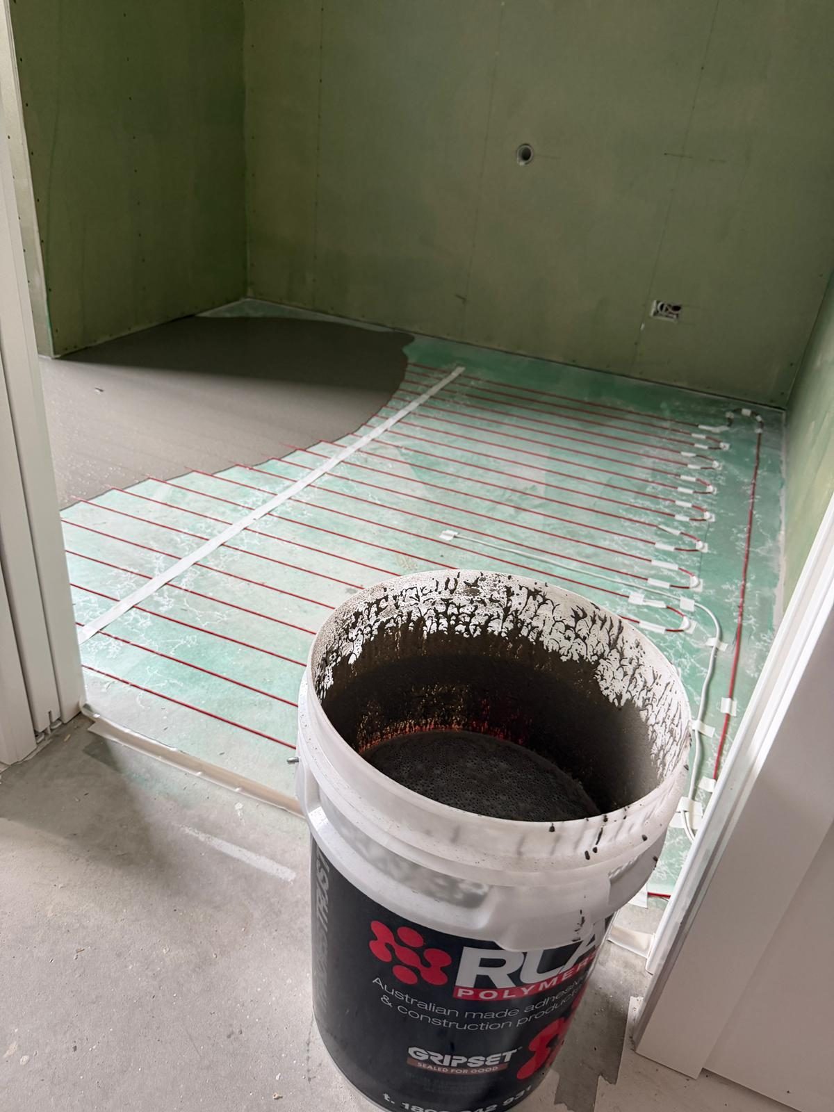 Underfloor heating cables being screeded before tiling